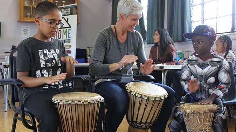 Teacher and children engaging in music lesson