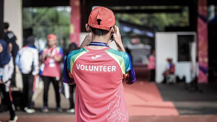 A volunteer team member taking a photo at a sporting event