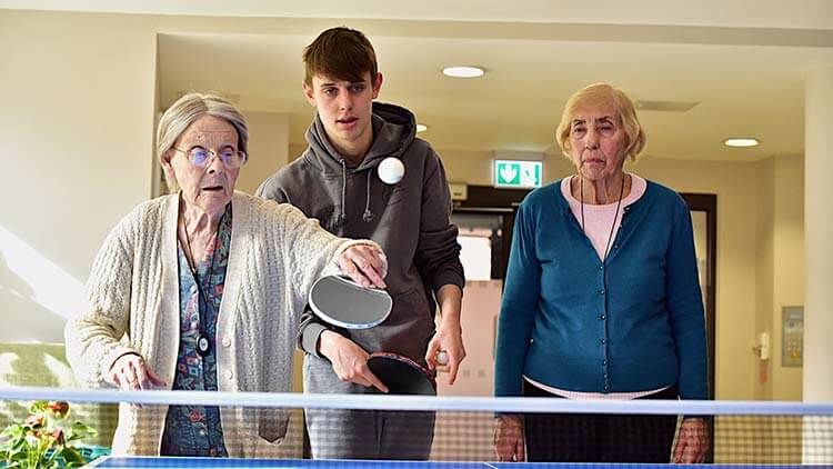 Senior citizens engaging in a friendly game of table tennis