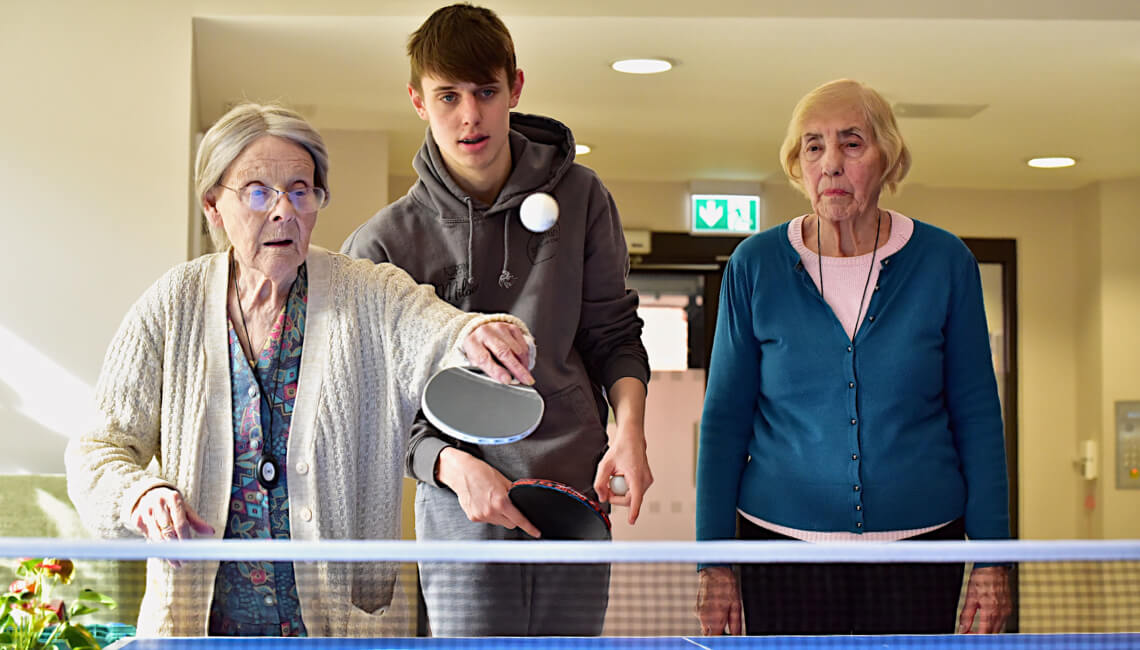 Senior citizens engaging in a friendly game of table tennis