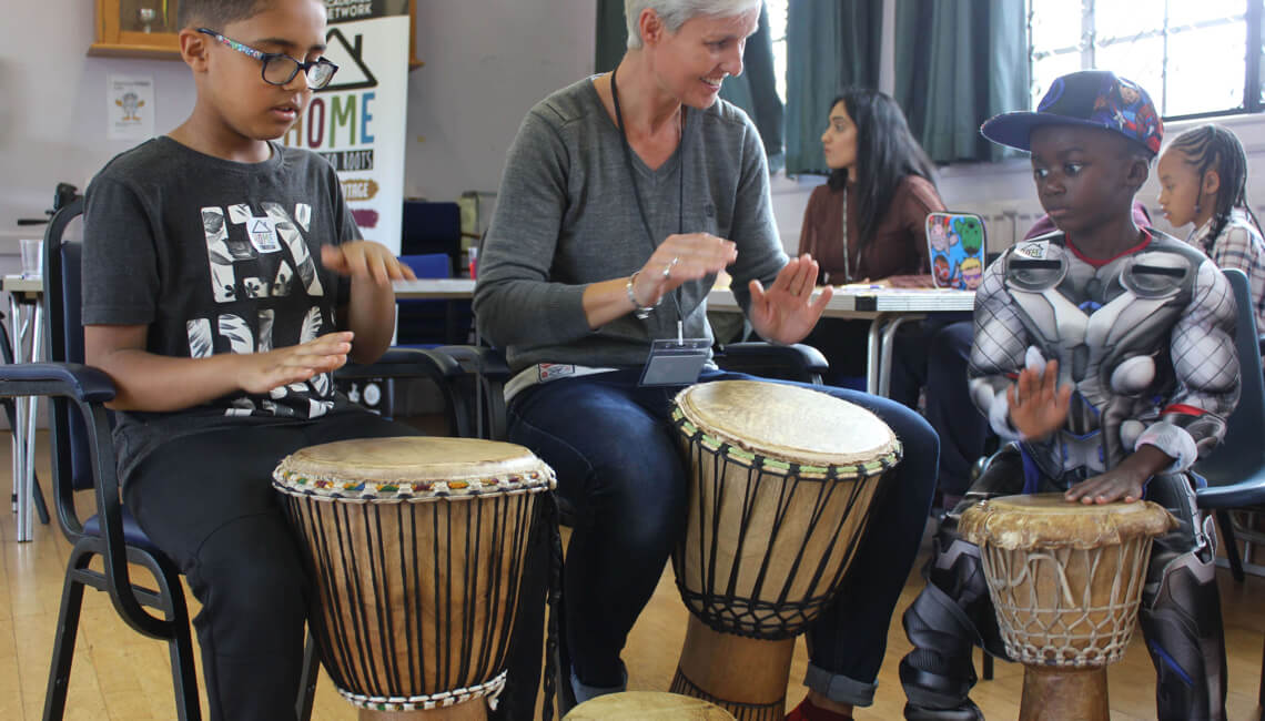 Teacher and children engaging in music lesson