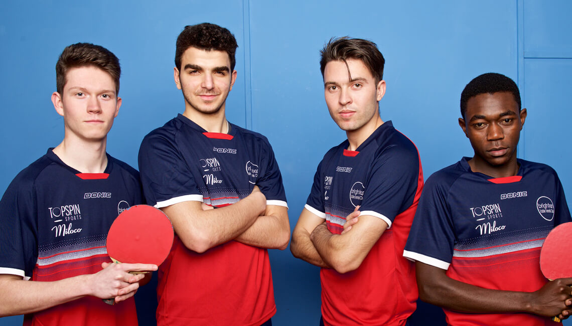 A table tennis team posing for a photo shoot
